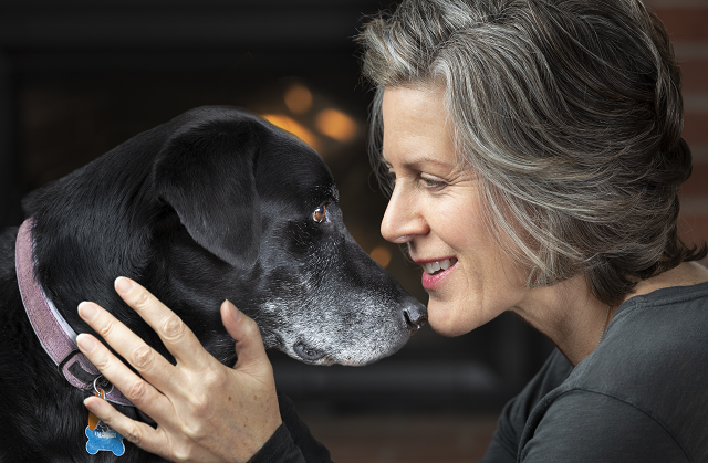 Silver haired lady with black lab